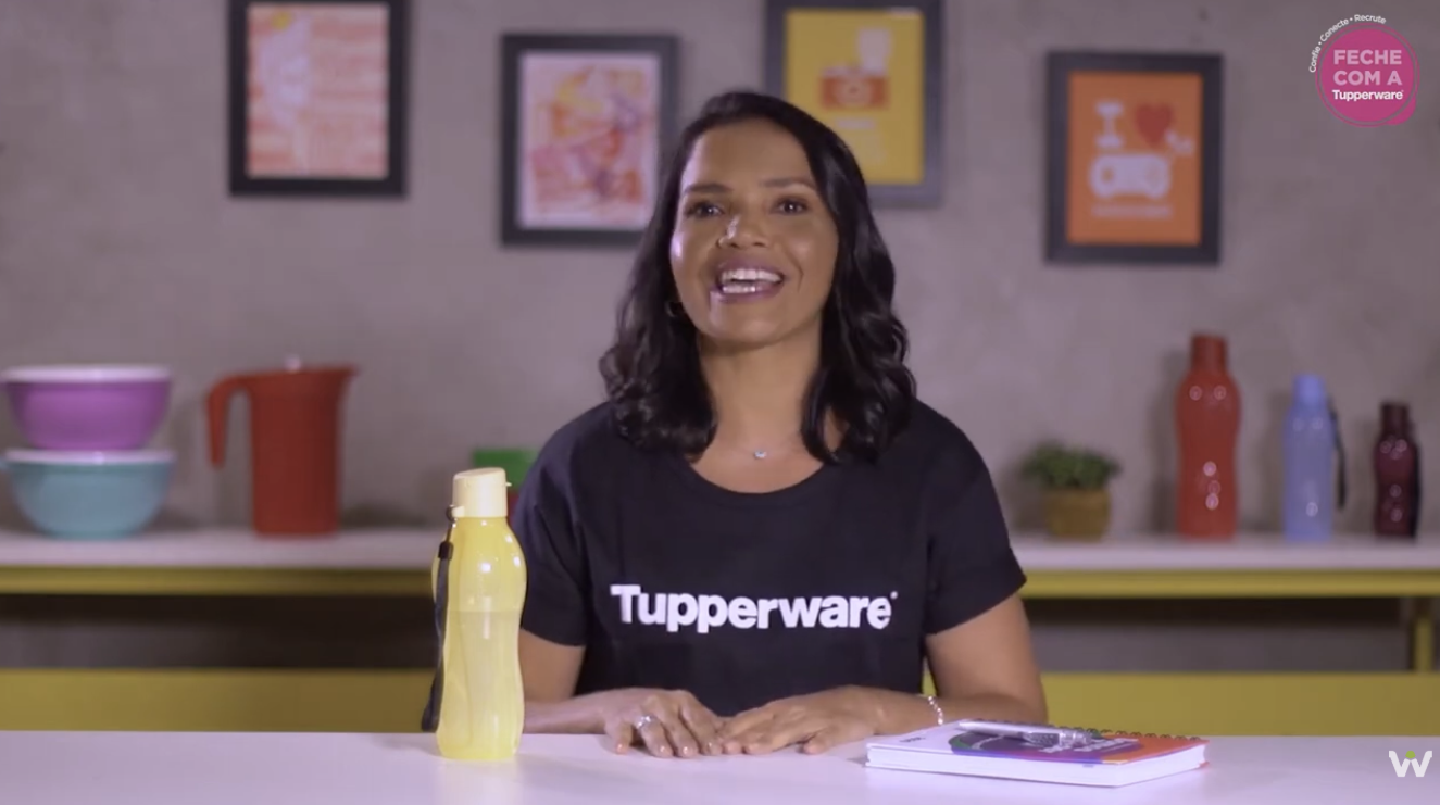 Apresentadora da Tupperware em cenário de estúdio com produtos da marca
