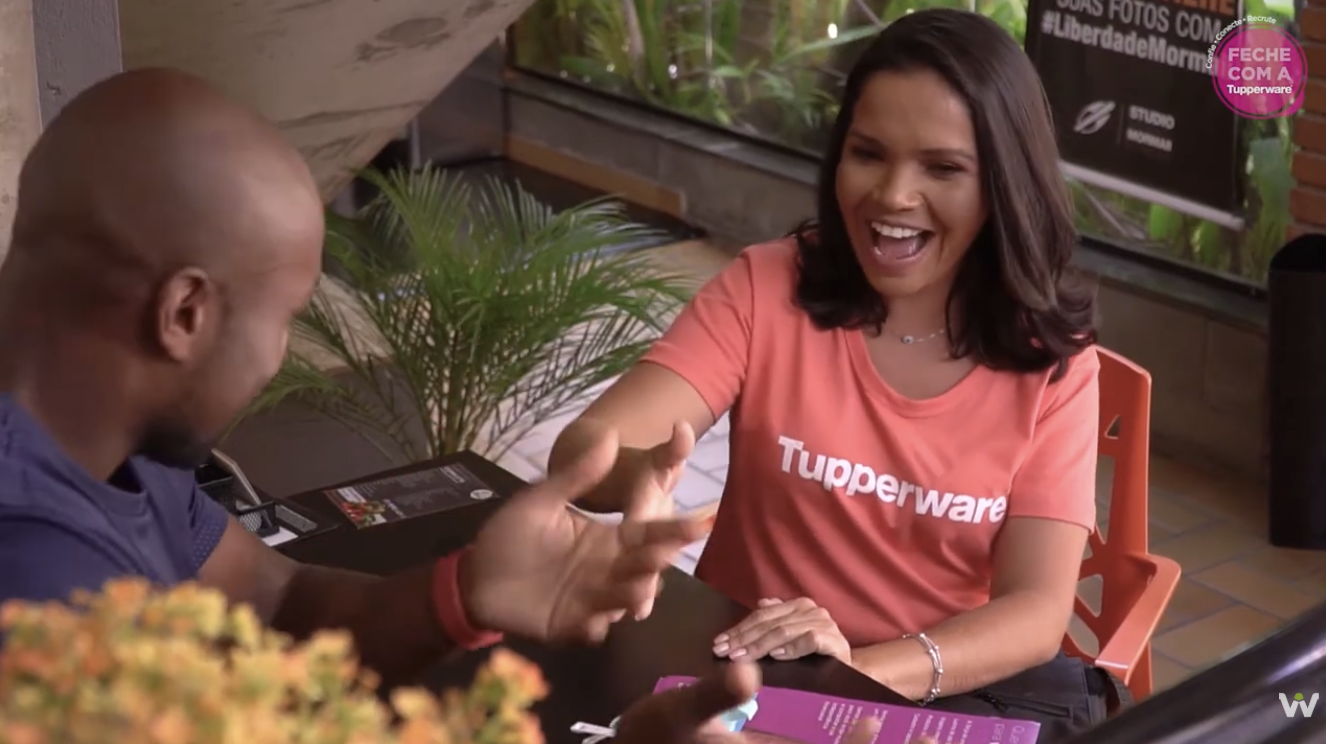 Revendedora Tupperware conversando com cliente em uma mesa