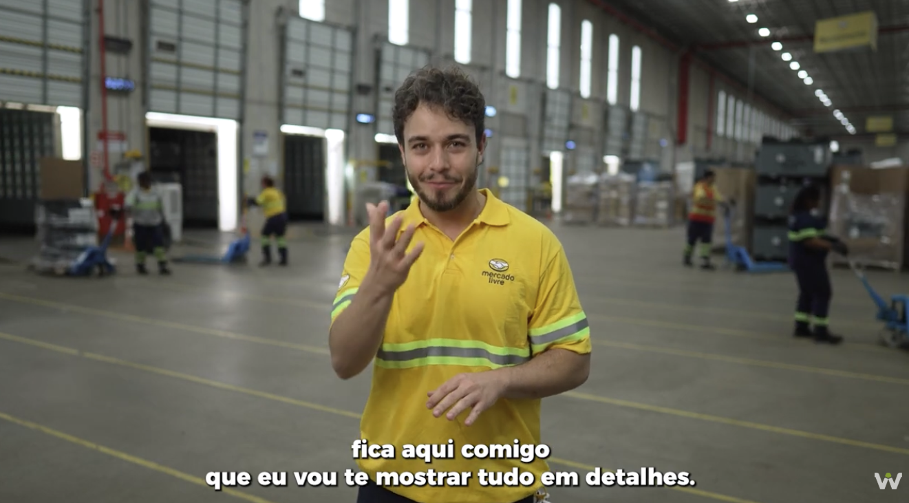 Apresentador conduzindo o tour pelo centro de distribuição do Mercado Livre