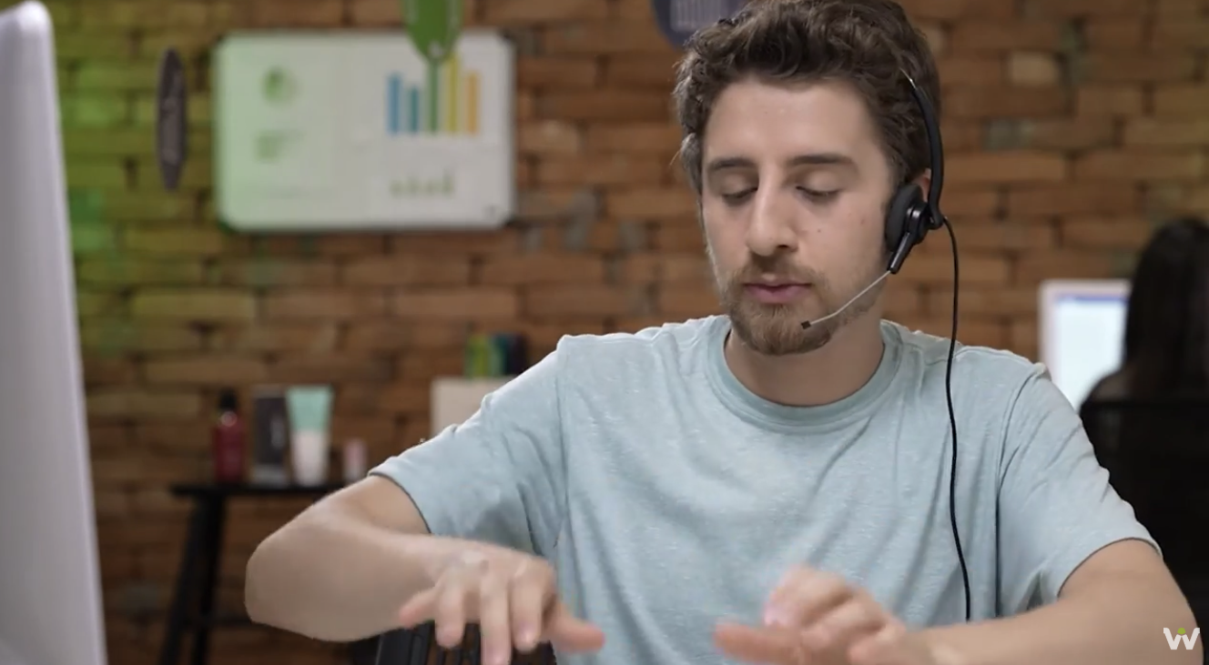 Ator interpretando atendente de call center com headset durante cena da série O Boticário