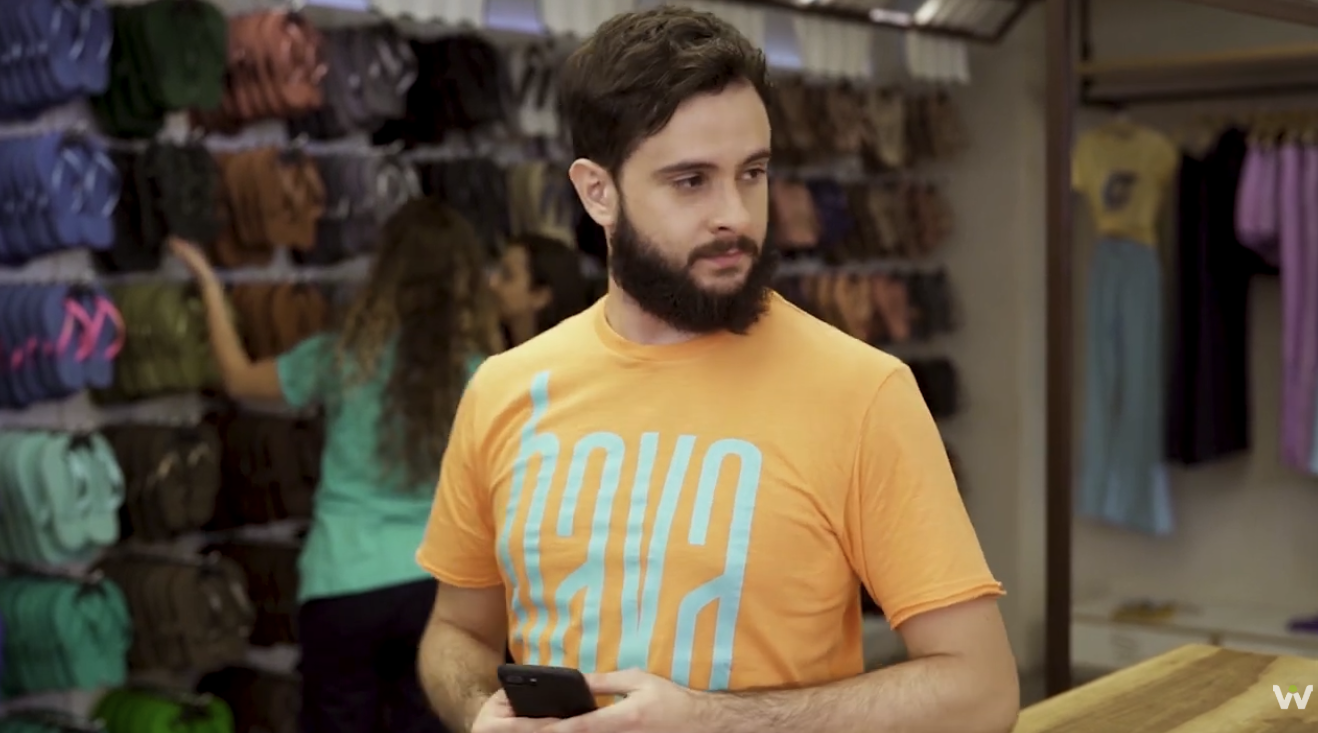 Ator interpretando vendedor da Havaianas com celular na loja